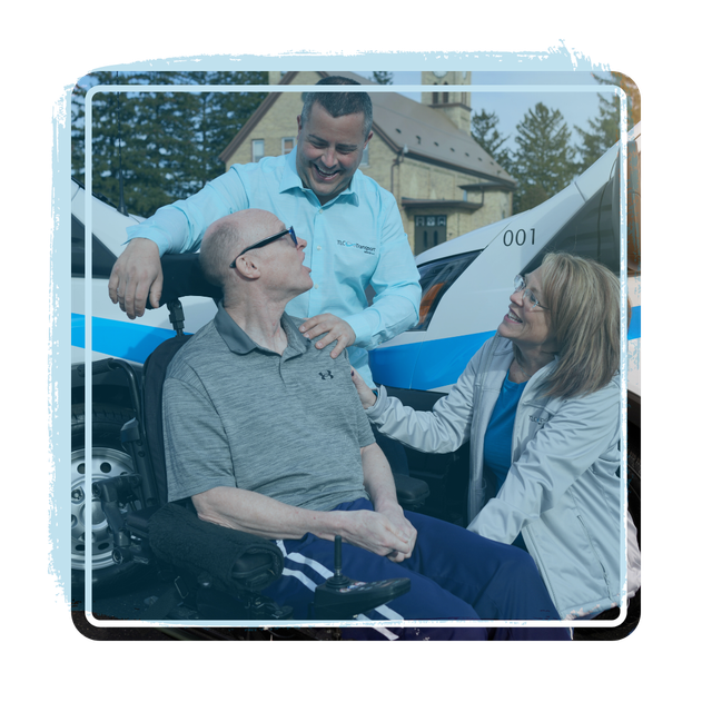 A man in a wheelchair is being helped by two people