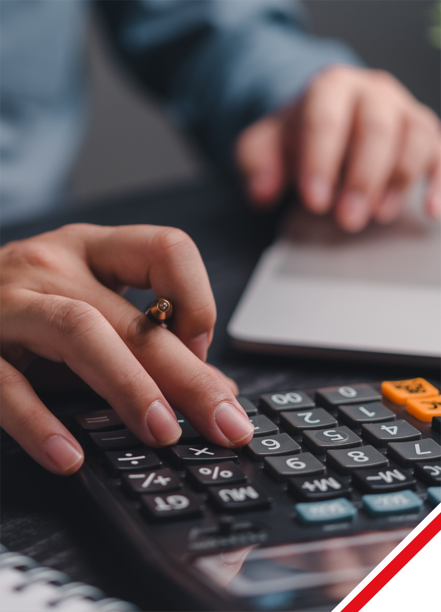 Two business people review charts and graphs at a table with a laptop and phone.