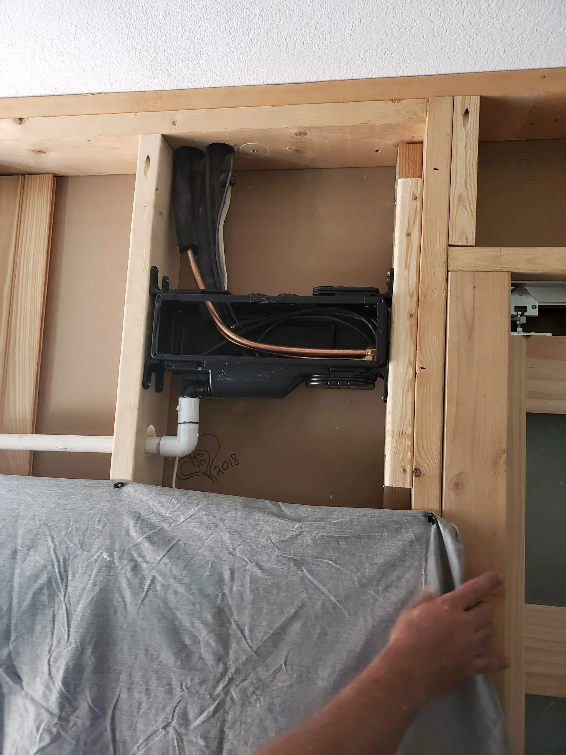 A person is holding a piece of cloth in front of a pipe