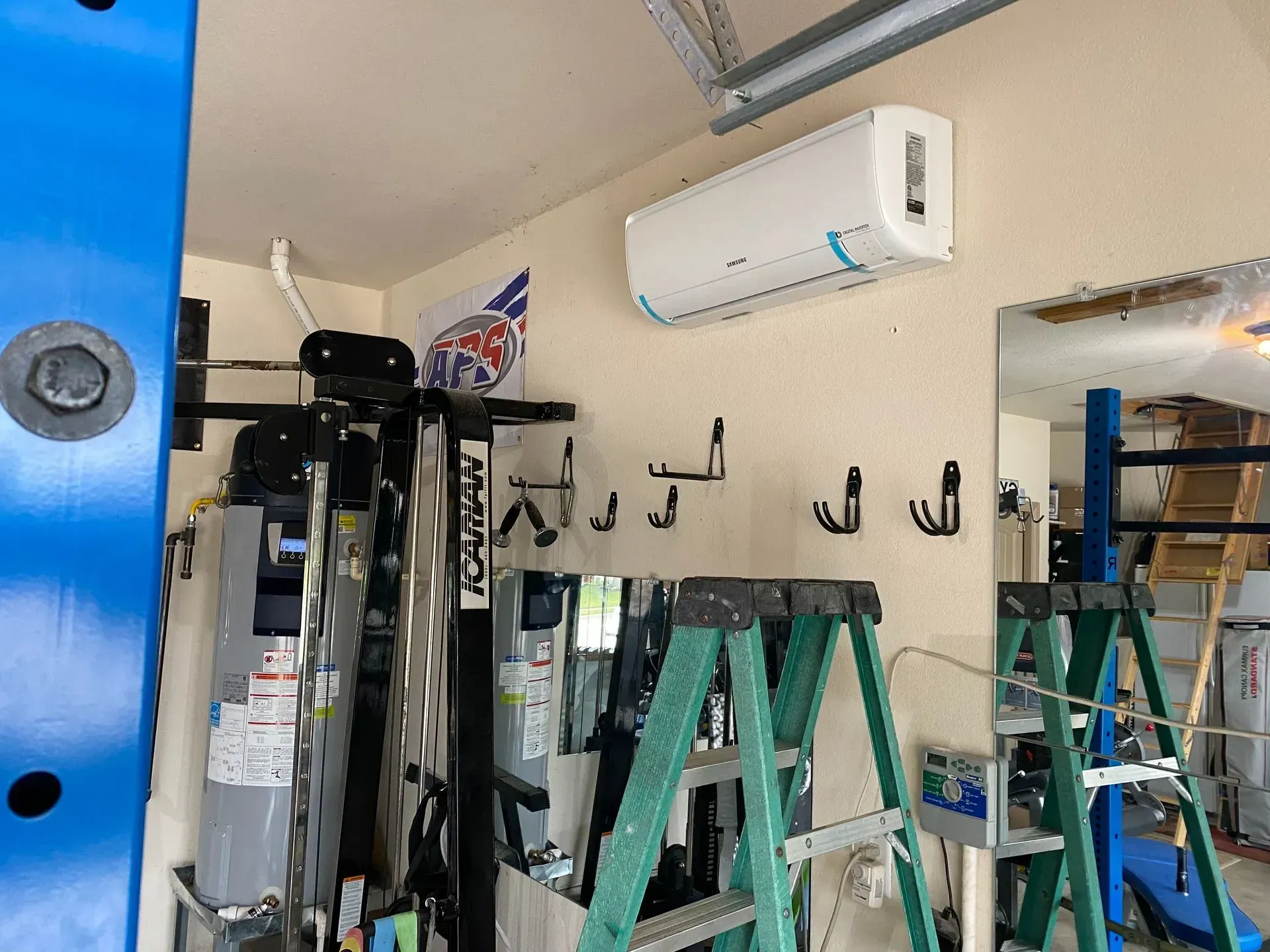 A garage with a lot of ladders and a wall mounted air conditioner.