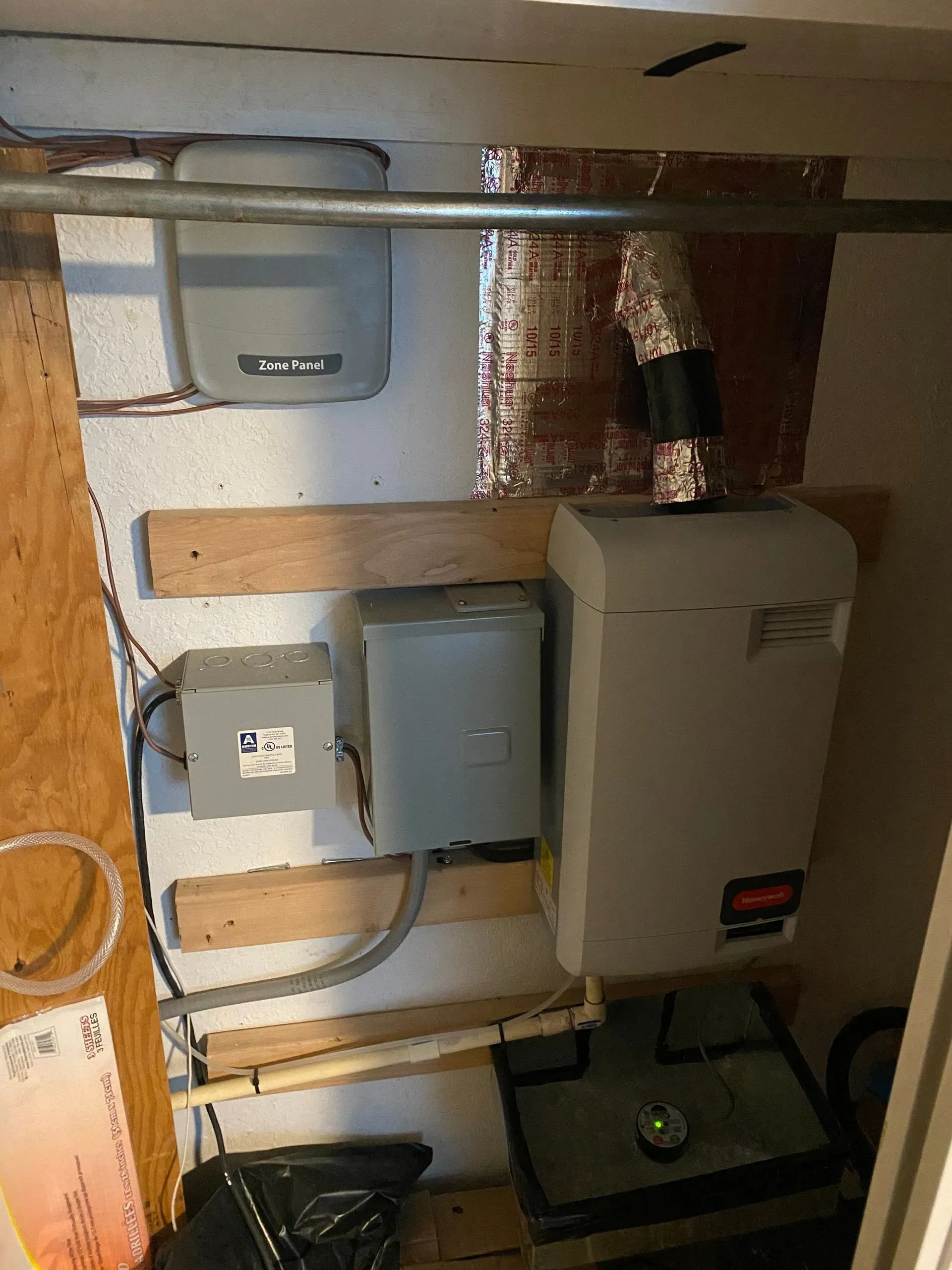 A room with a lot of wires hanging from the wall and a box on the wall.