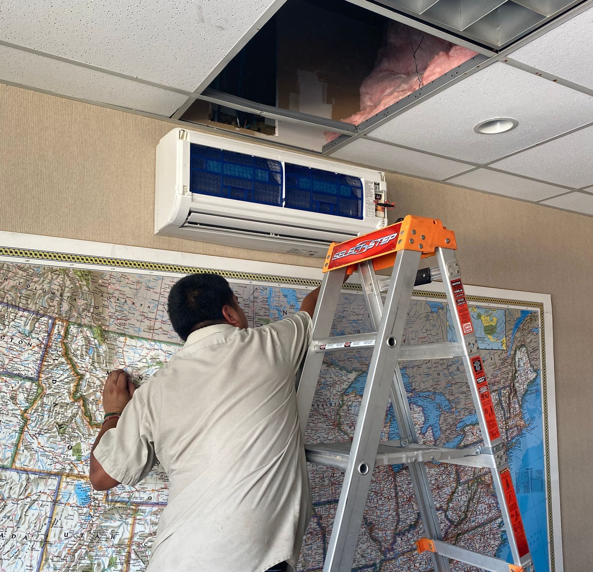A technician is checking an air conditioning unit.
