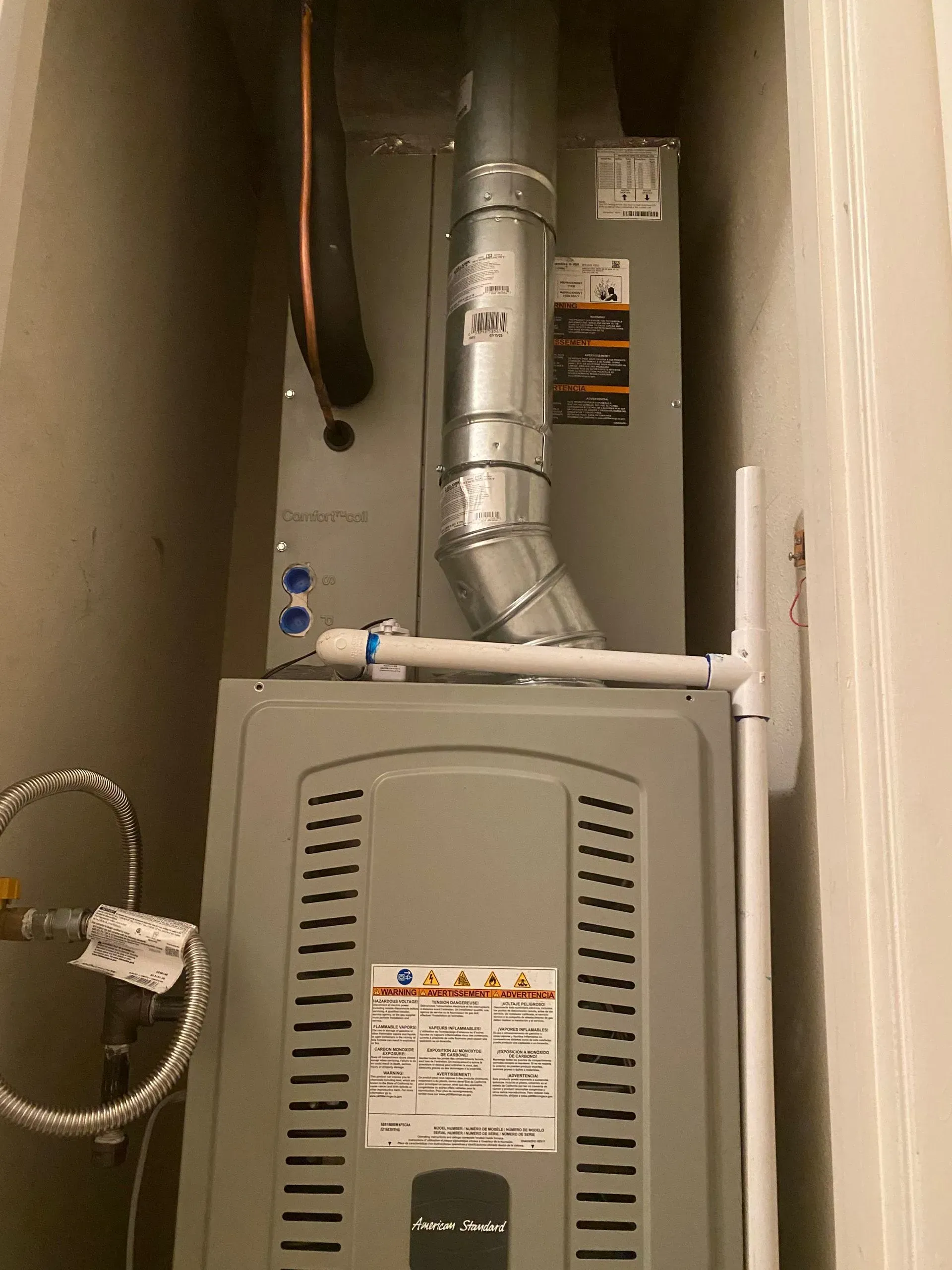 An air conditioner is sitting in a corner of a room.