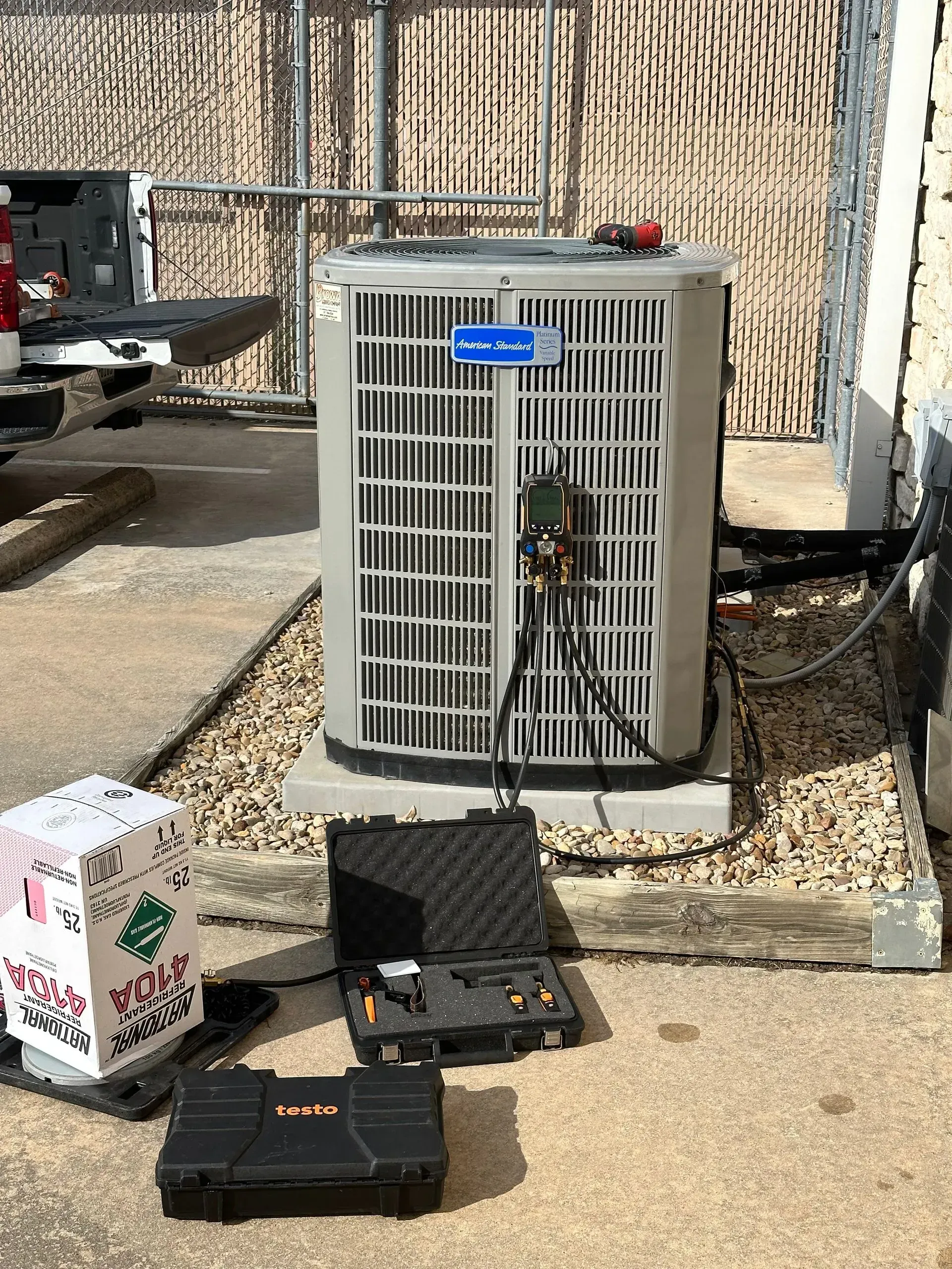 An air conditioner is sitting on the ground next to a box that says hello world.