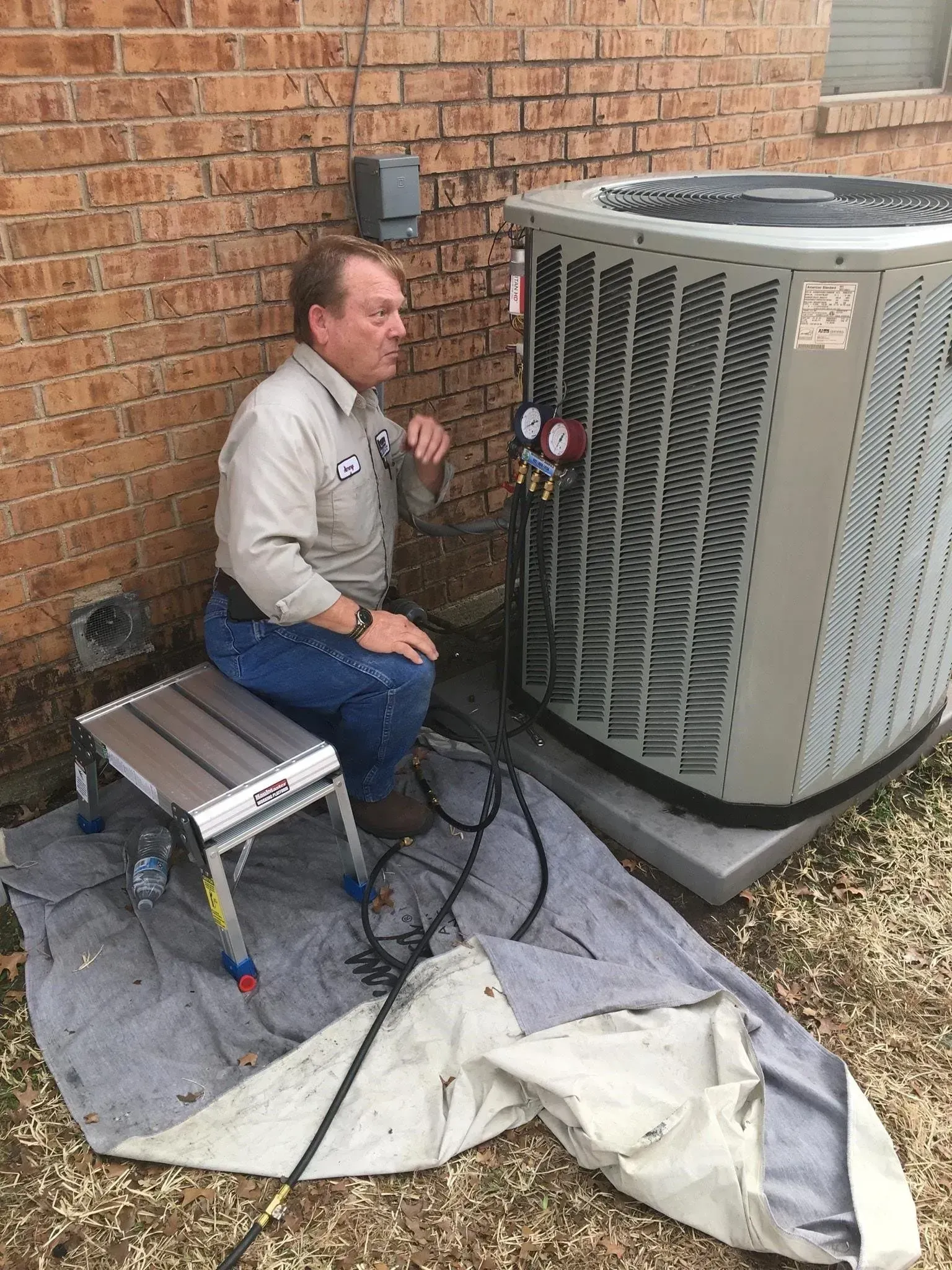A male technician is checking an outdoor unit.