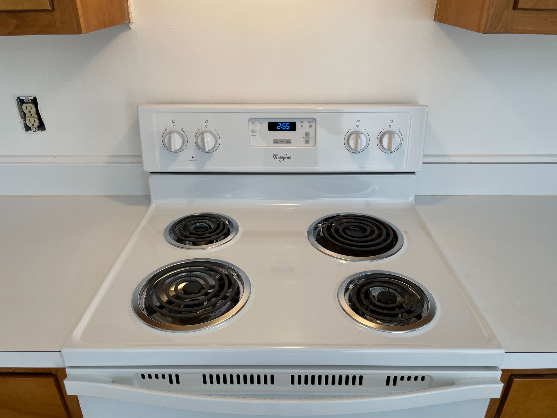 a white stove with four burners and a digital display