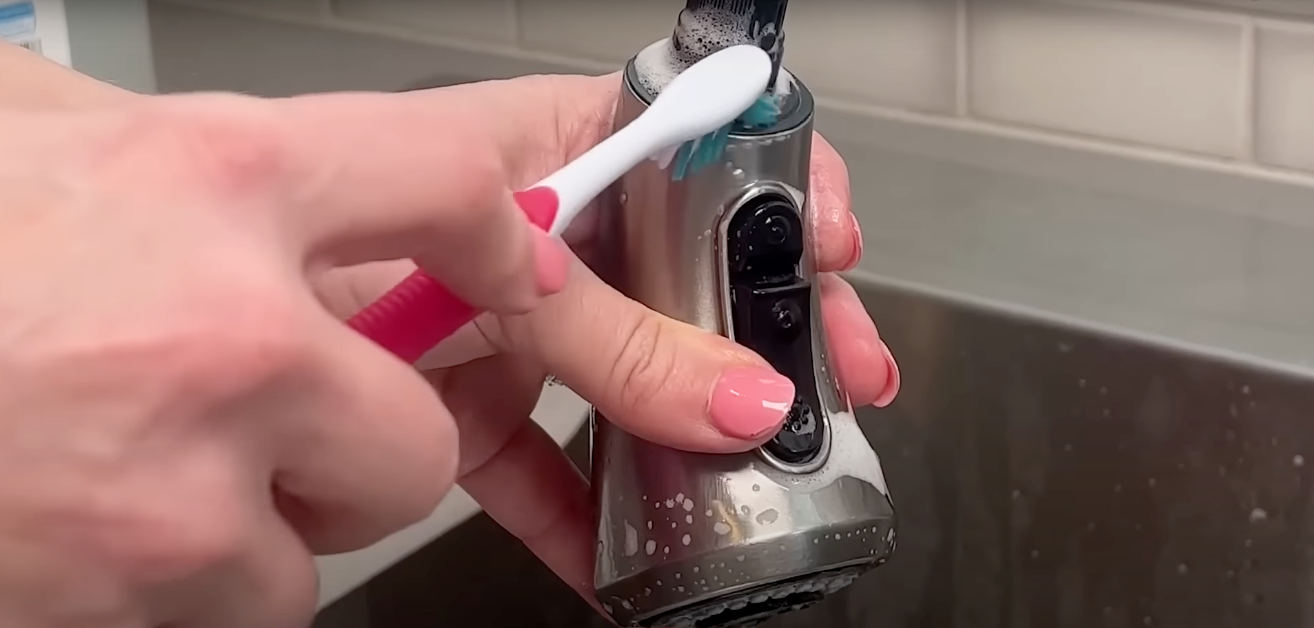 a person is cleaning an electric razor with a toothbrush .