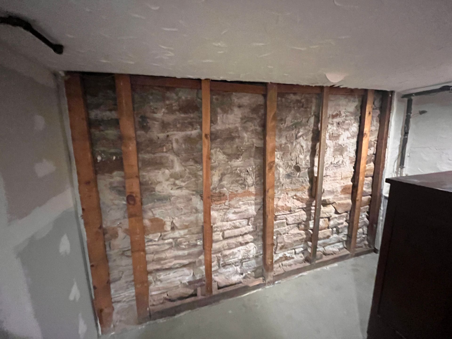 A room with a brick wall and wooden beams.