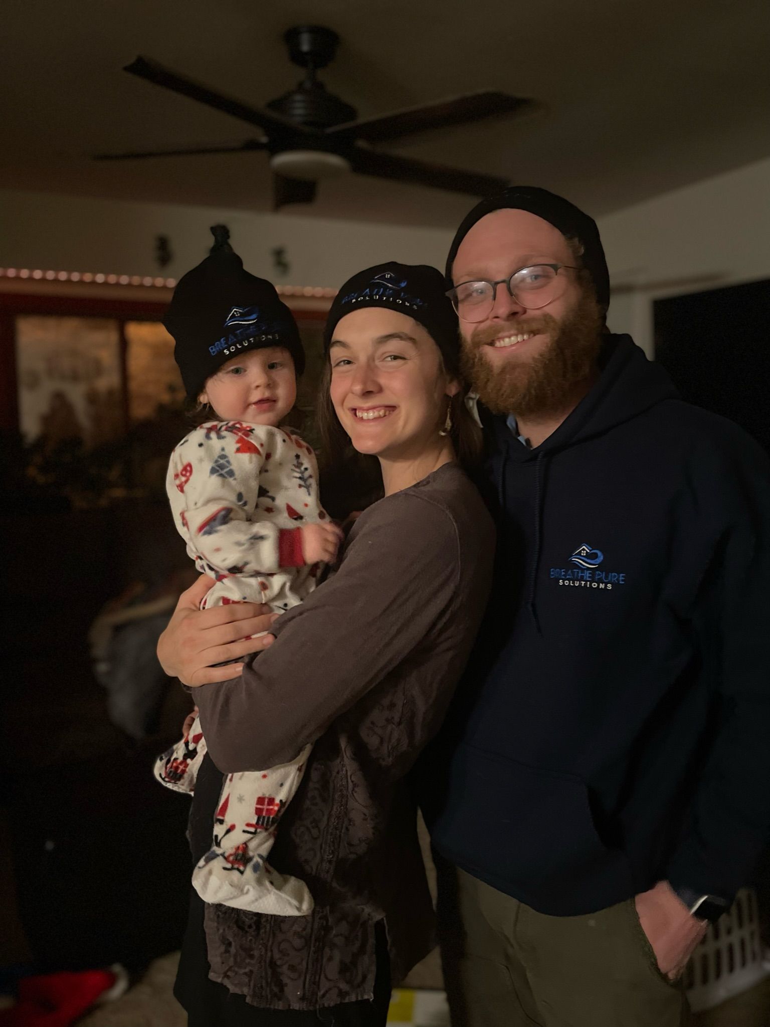 A man and woman holding a baby in a living room