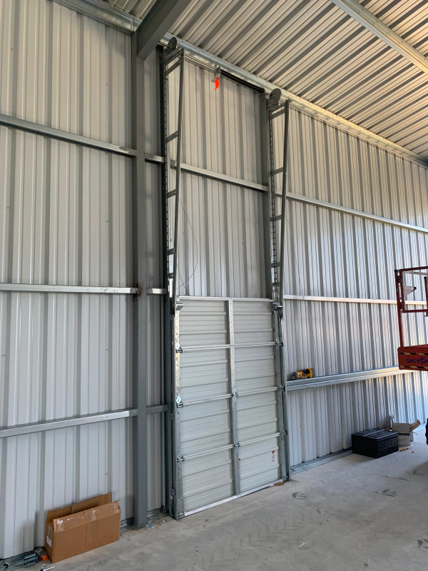 A large metal door is being installed in a building.