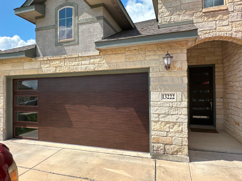A large brick house with a brown garage door.