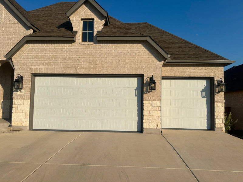 A large brick house with two white garage doors