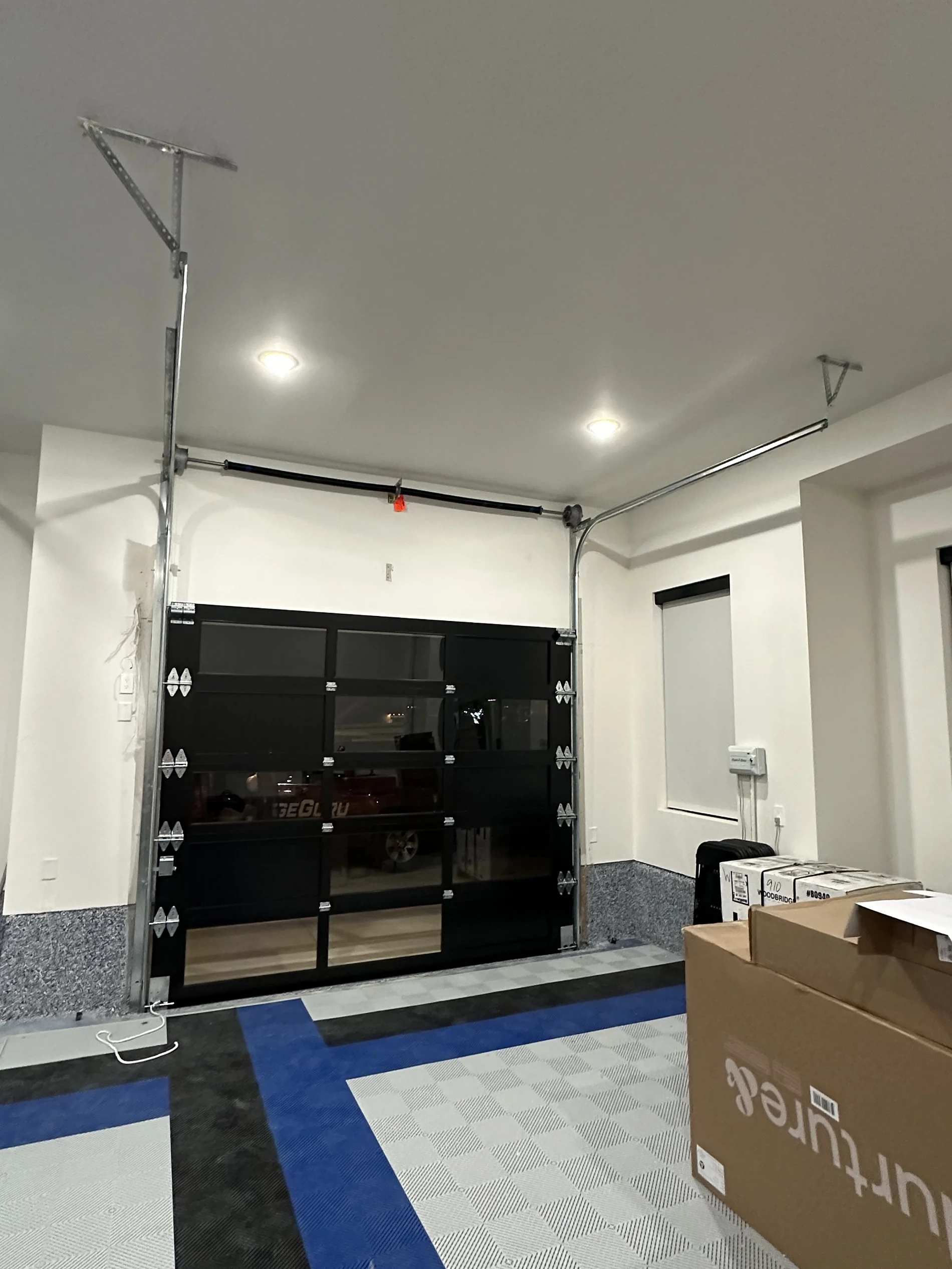 A garage with a black garage door and a box that says ' urfour ' on it