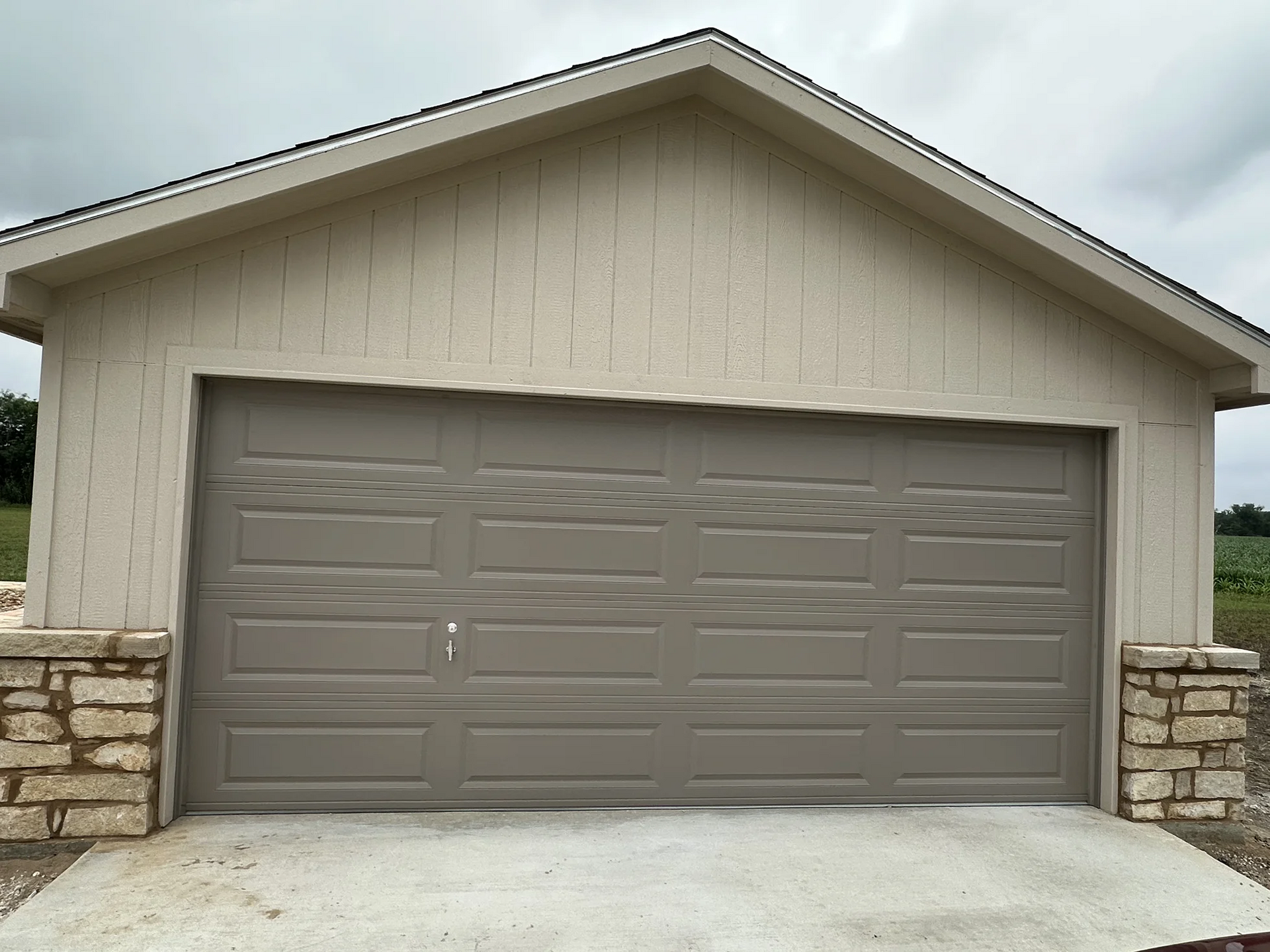 A garage with a large garage door and a stone wall