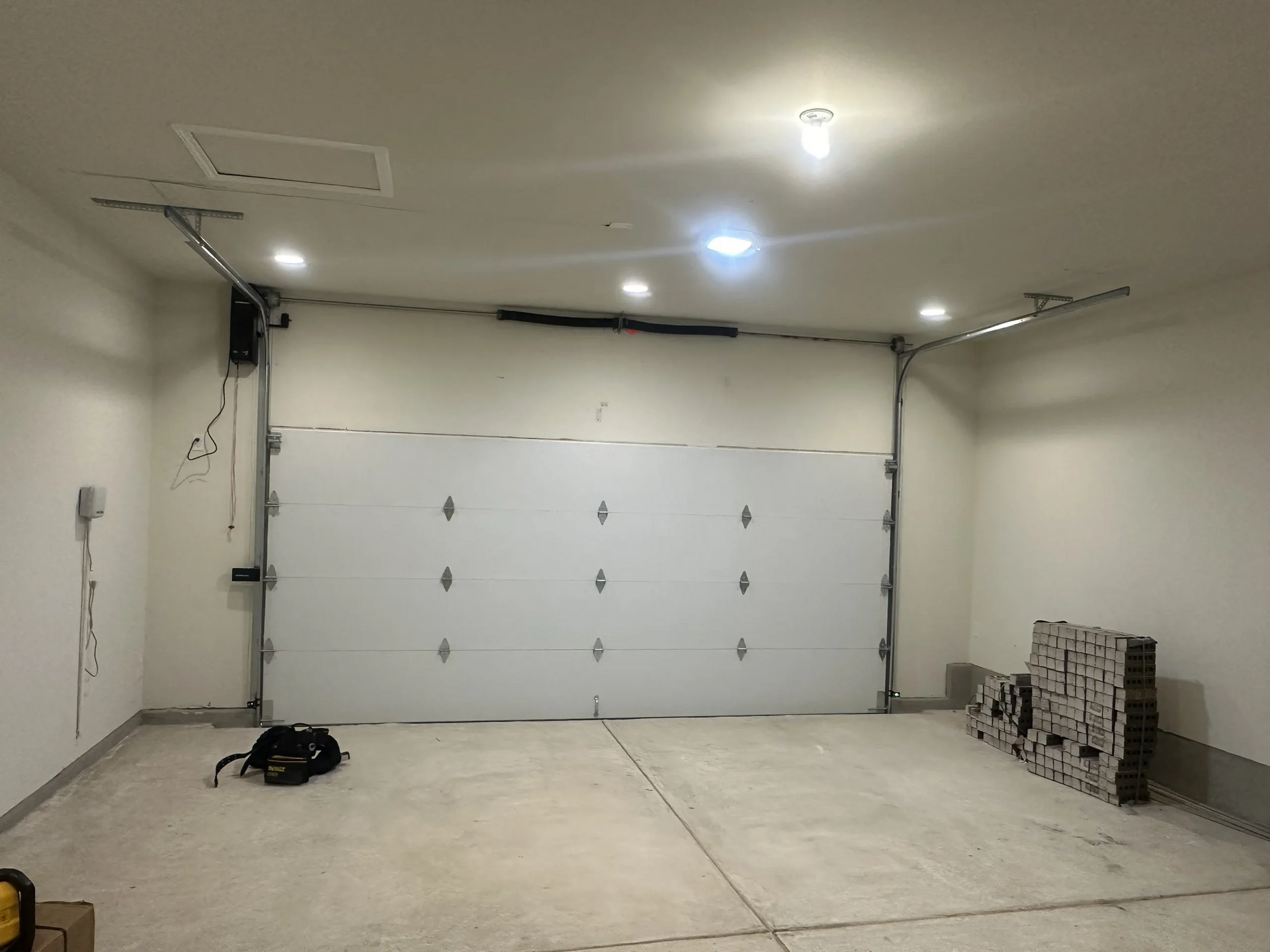 An empty garage with a large white garage door