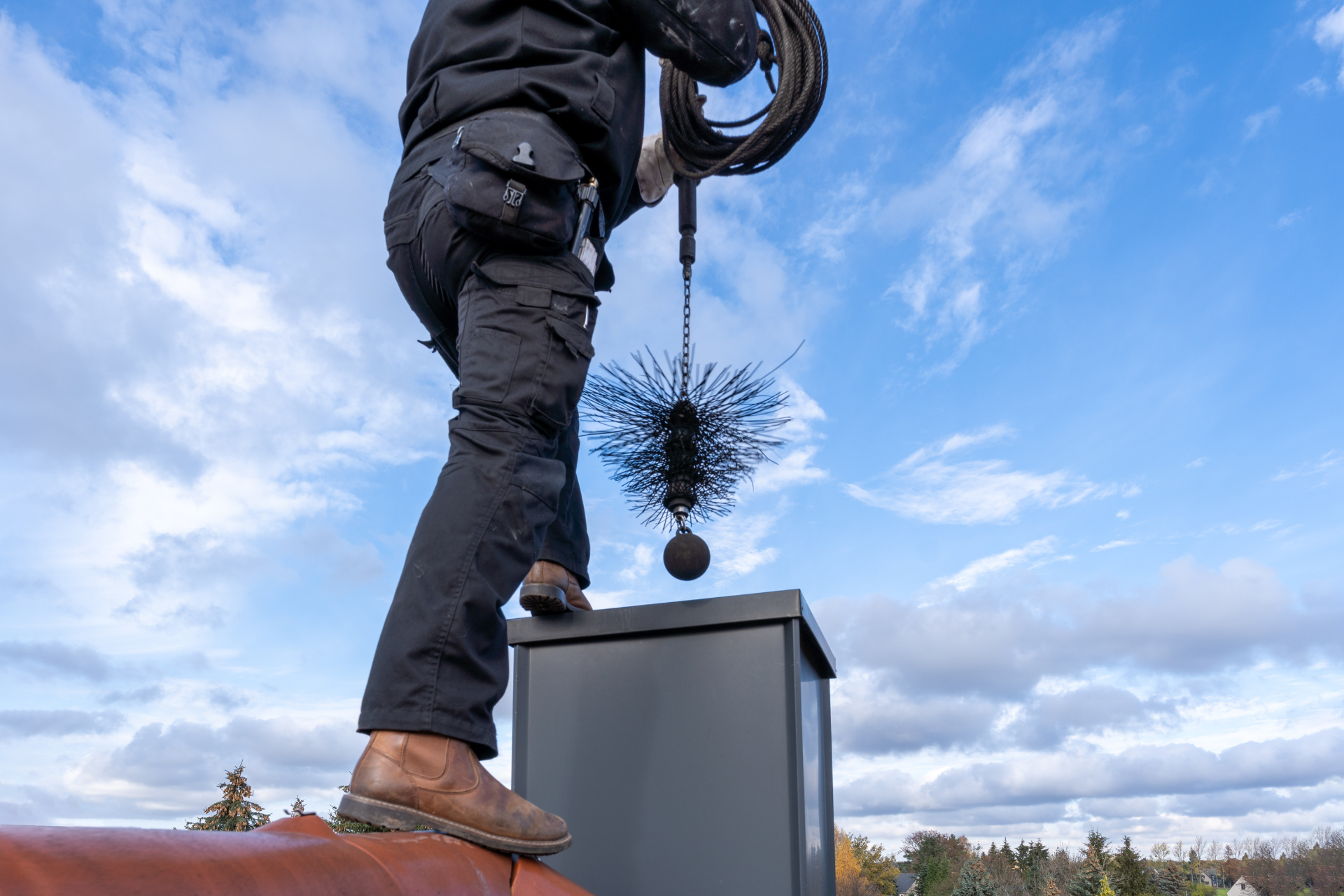 A man is cleaning a chimney with a brush.