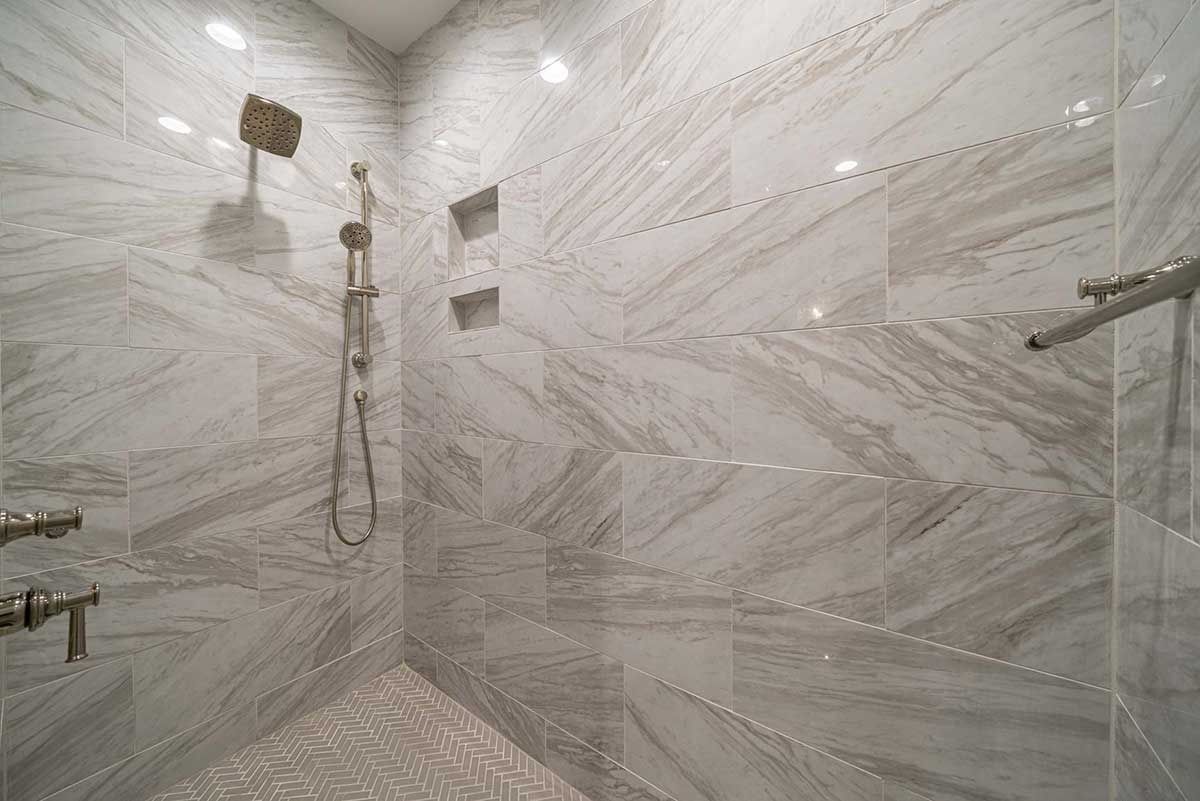 Modern marble-tiled shower room with glass enclosure and chrome fixtures