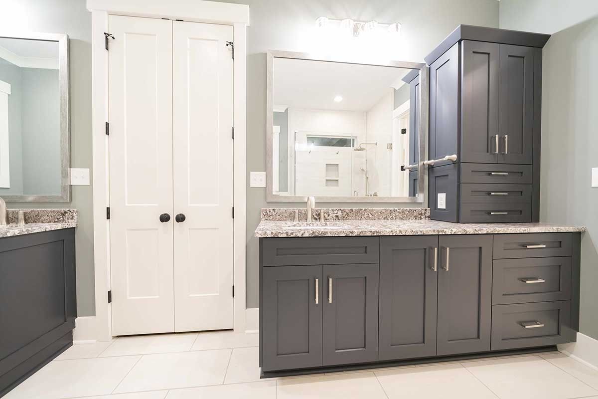 Modern bathroom with gray vanities, white tile floor, and a double-sink mirror wall