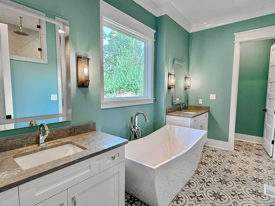Light aqua bathroom with freestanding tub, vanity, and patterned tile floor
