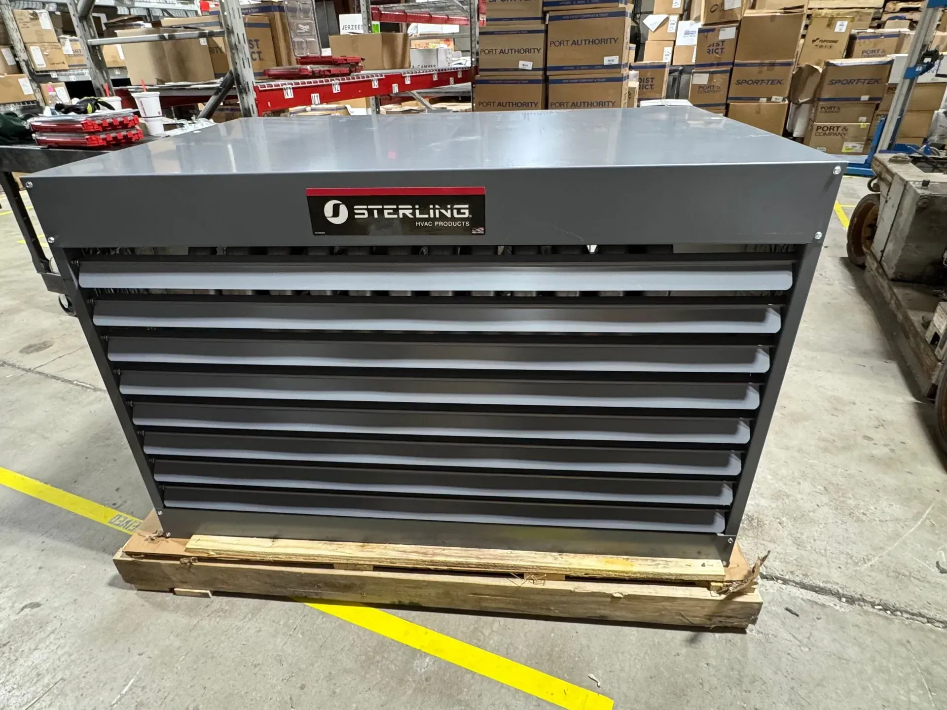 Gray Sterling industrial cabinet with horizontal louvers, on a wooden pallet in a warehouse setting.