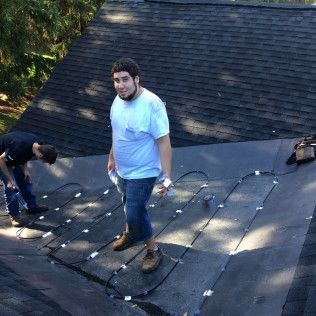 Two men are working on the roof of a house.