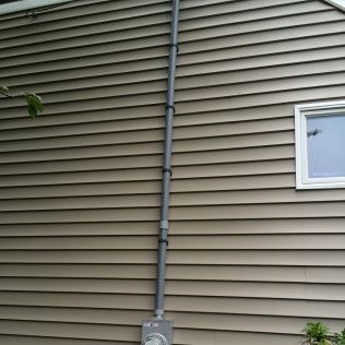 A house with a window and a pipe on the side of it.