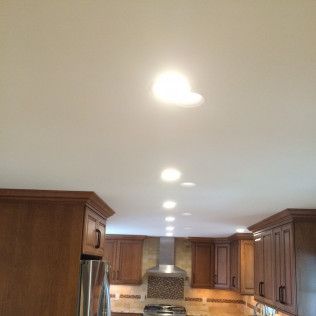 A kitchen with wooden cabinets and a white ceiling.