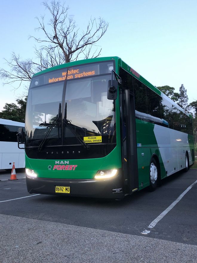 Serviceman with digital tablet. In the background is a bus in the garage.
