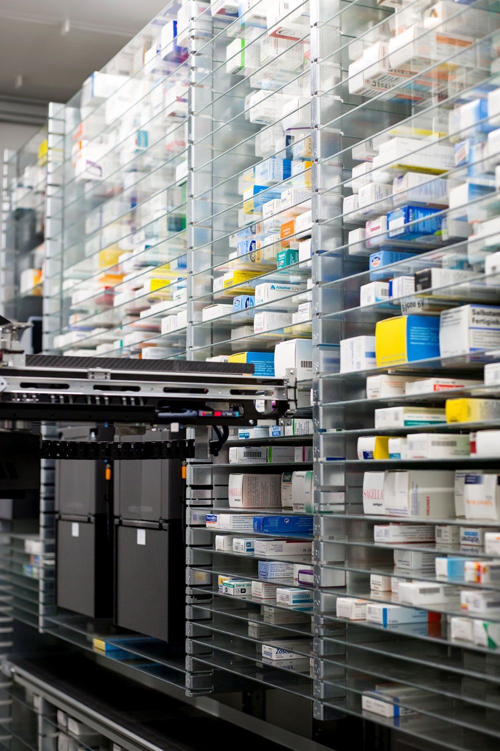 In einer Apotheke stehen eine Reihe Regale voller Medikamentenpackungen.