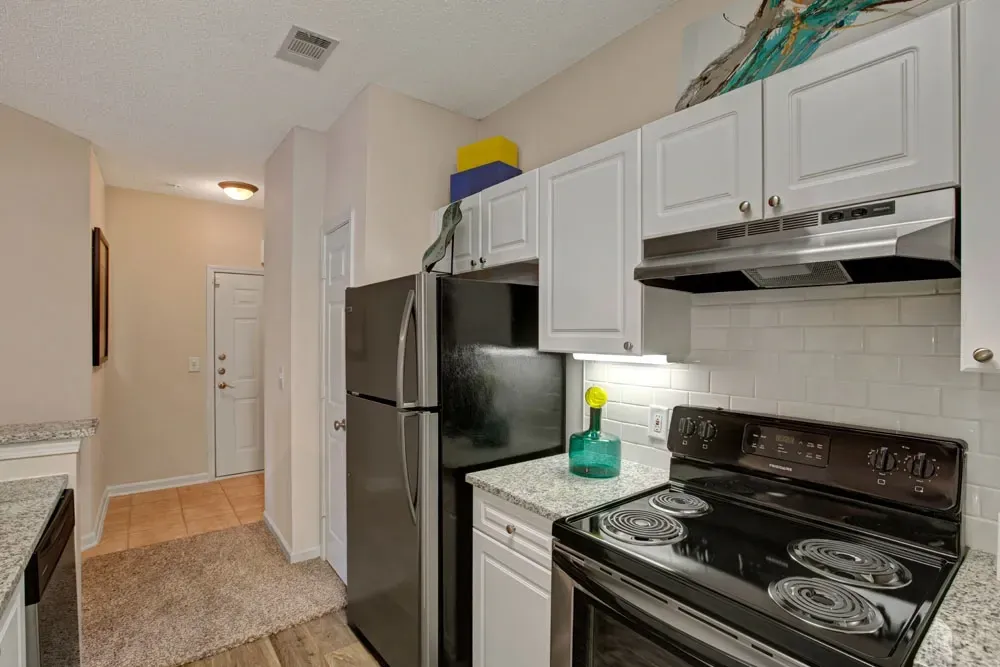 A kitchen with a black stove top oven and a black refrigerator.