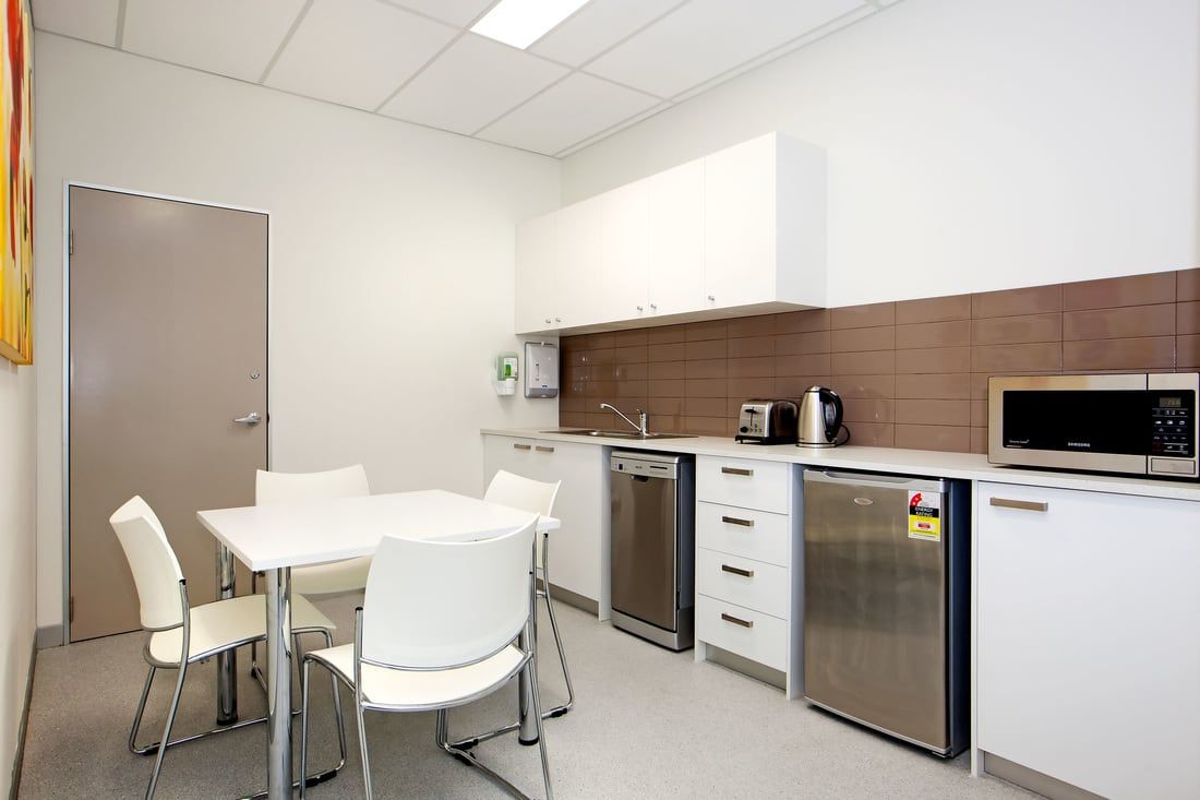 A kitchen with a table and chairs and stainless steel appliances