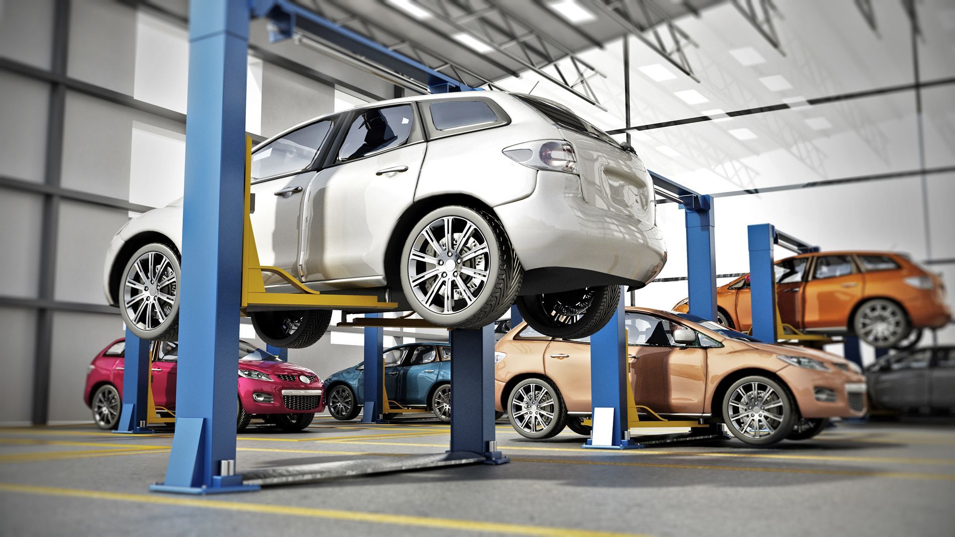 Cars on lifts in a repair shop. Various colored vehicles being serviced.