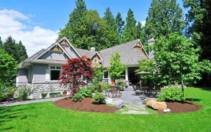 A well-maintained garden with various colorful flowers and plants, arranged on tiered stone walls and steps, creates a serene and vibrant outdoor scene.