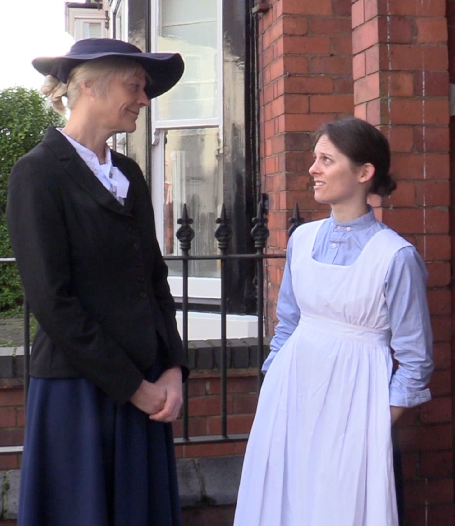 a group of people in costume posing for a picture in front of a painting