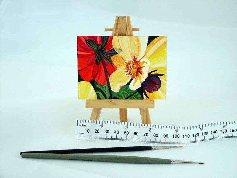 a painting of flowers on an easel next to a ruler