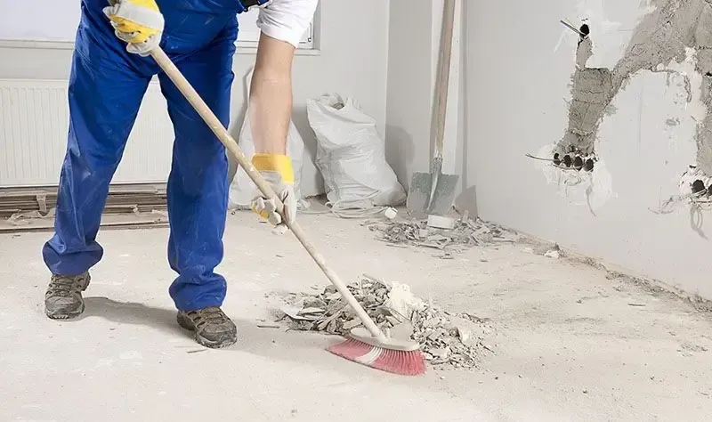 A man is sweeping the floor with a mop.