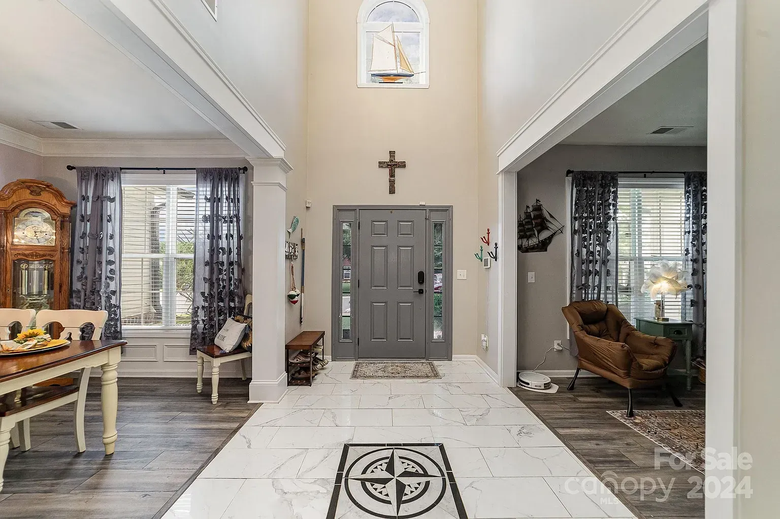Entryway with gray front door, cross, and nautical floor tile.