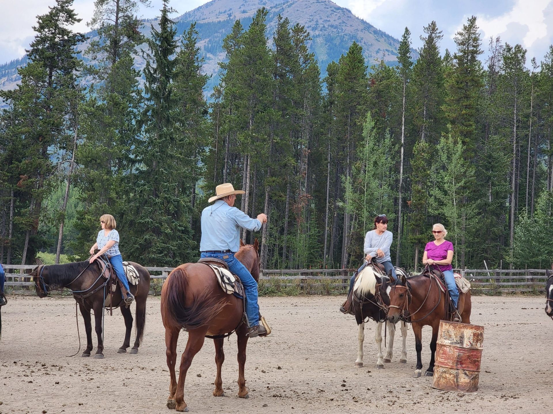 A group of people riding horses with a mountain in the background