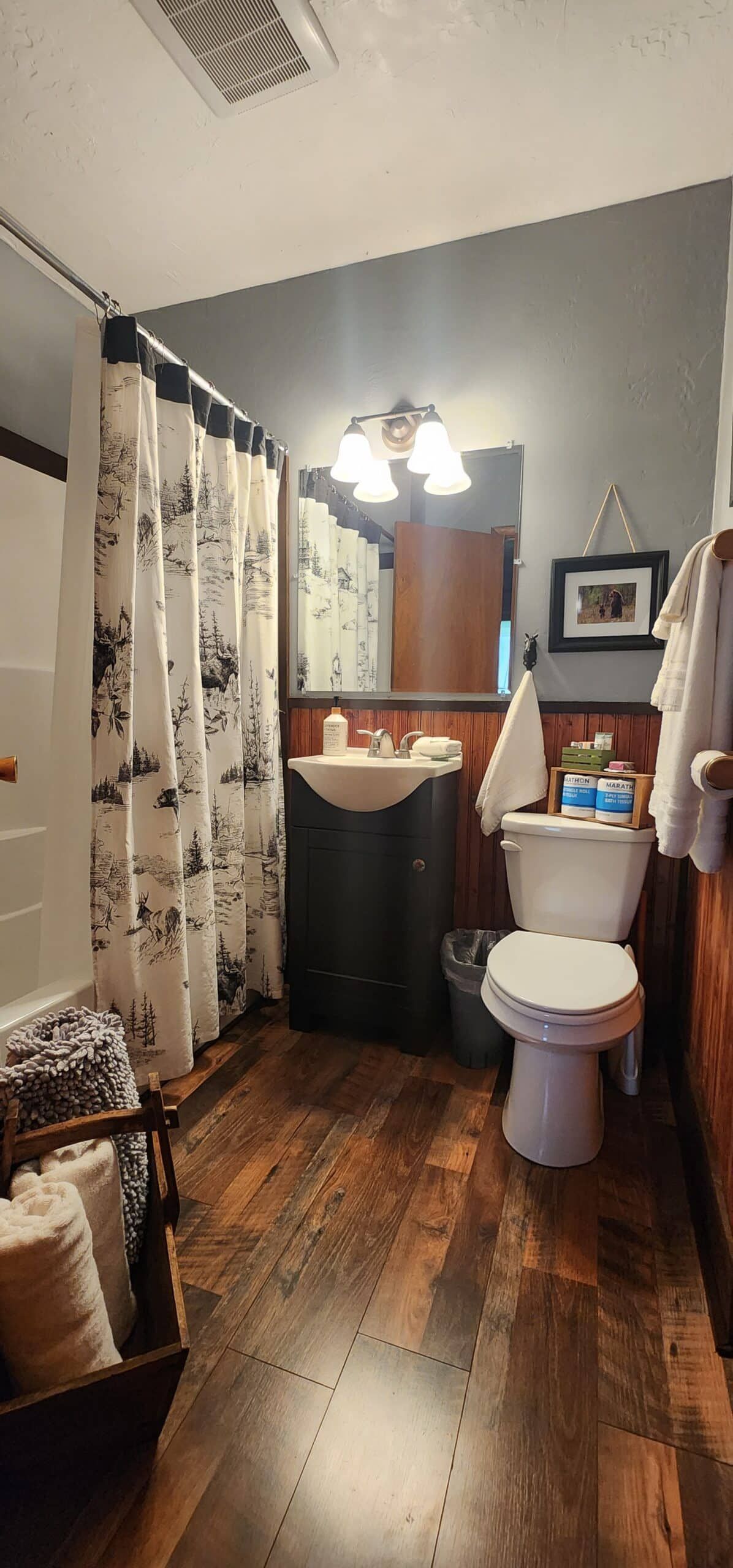 A bathroom with a toilet , sink , and shower curtain.