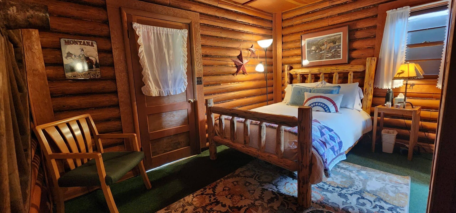 A bedroom in a log cabin with a bed and chair.