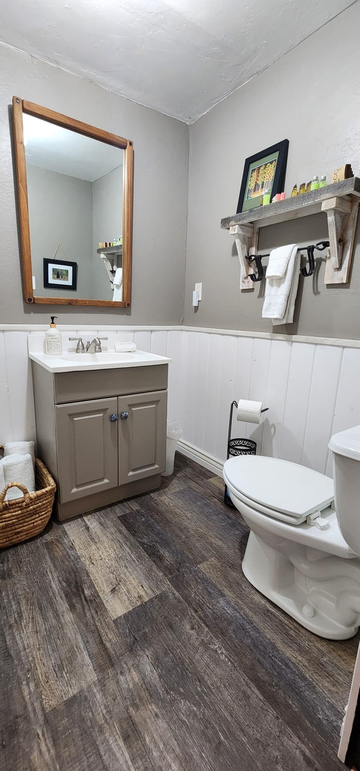A bathroom with a toilet , sink and mirror.
