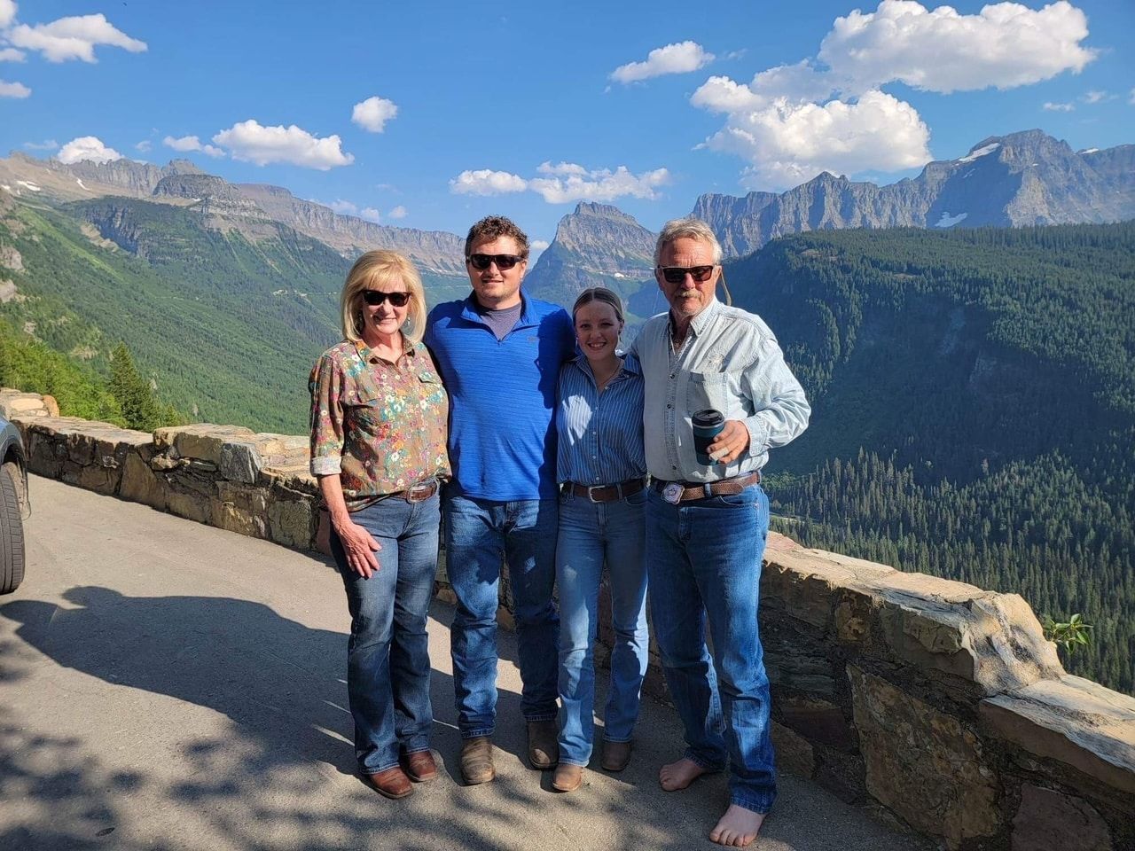 A group of people are posing for a picture in front of a mountain range.