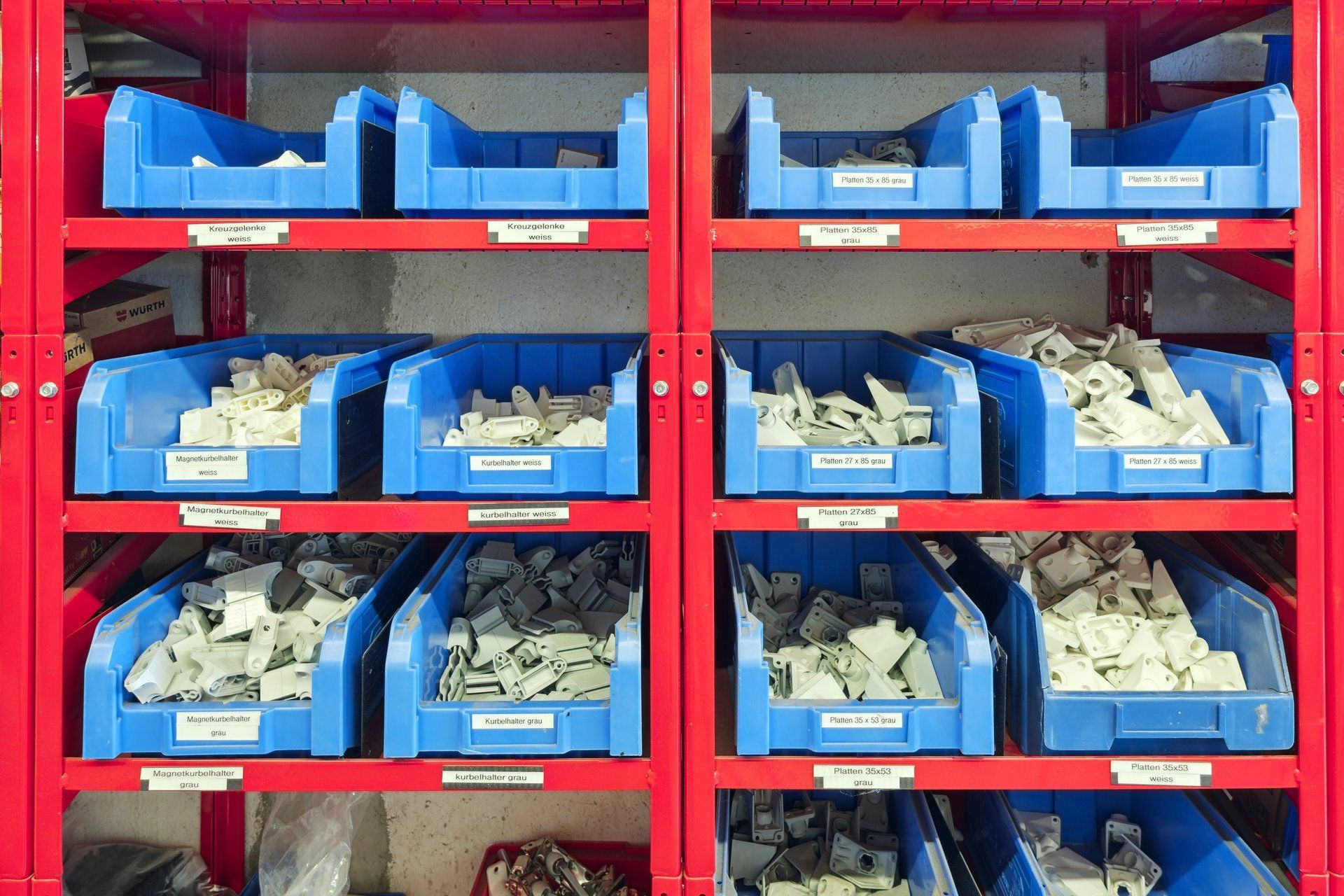 Ein Lagerhaus voller blauer Behälter und roter Regale.