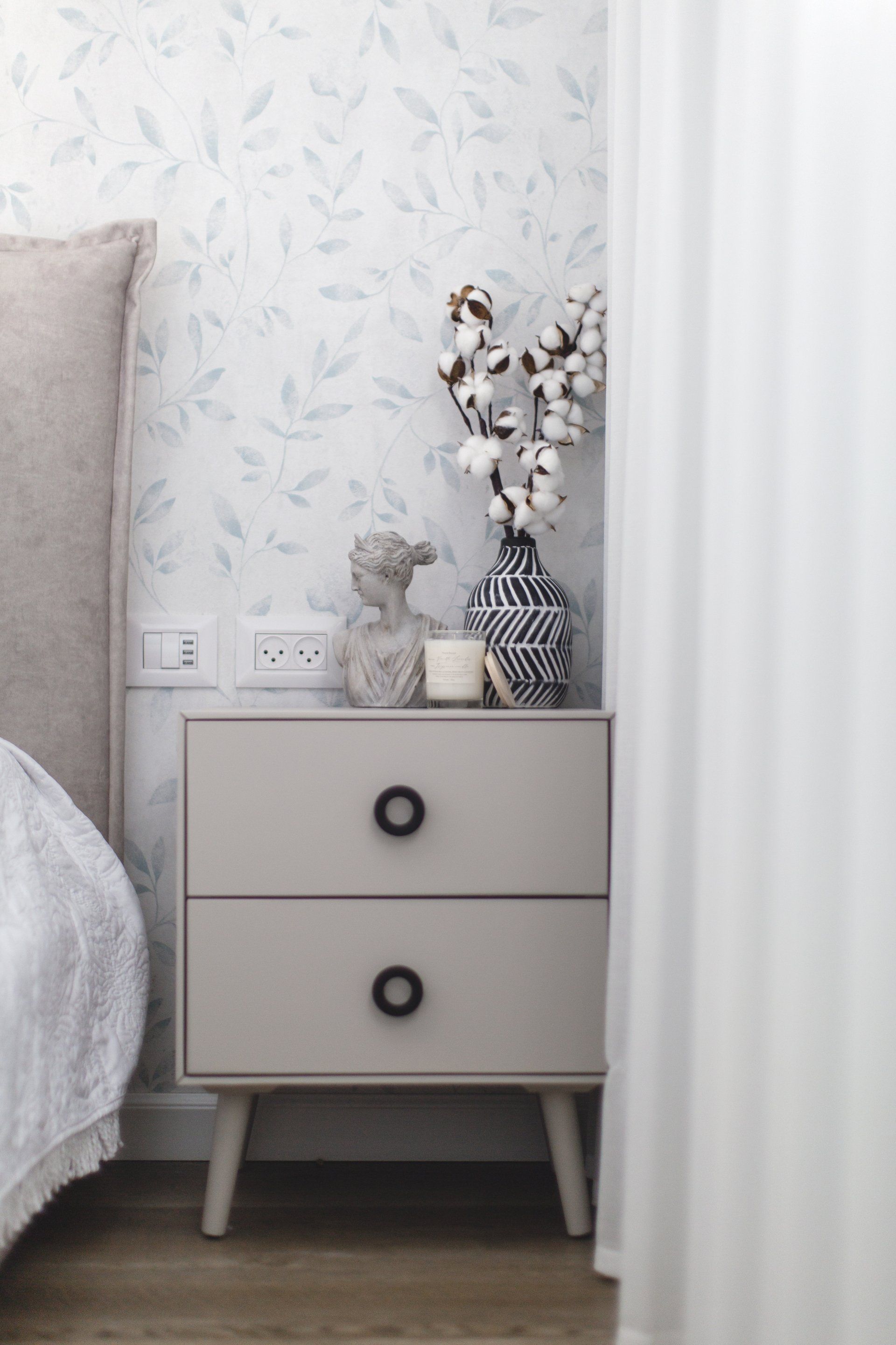 ענפי כותנה, נר ריחני ופסל קטן  לישון בסוויטה פסטלית בעיצוב של מעצבת פנים ומלבישה בתים ג׳ני ויאליך jenyvstudio