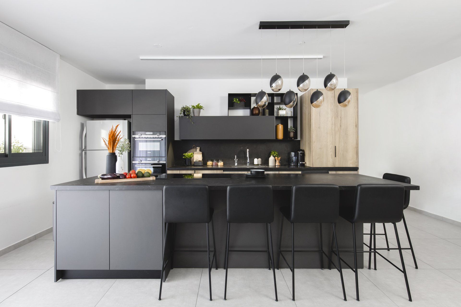 הלבשת חלל סלון ומטבח בגווני אפור שחור וחרדל. שפע של צמחים.  שחור-אפור וכל מה שבניהם בעיצוב של מעצבת פנים ומלבישה בתים ג׳ני ויאליך jenyvstudio