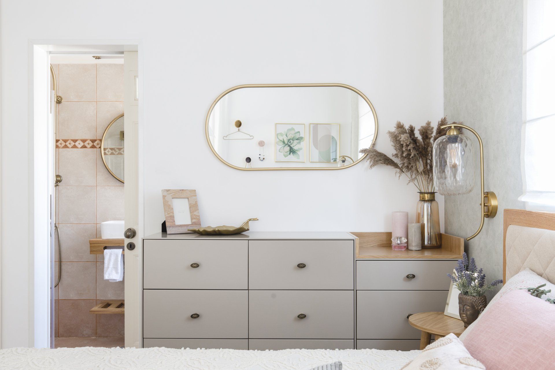 חדר שינה רומנטי עם שידה אפורה ומראה אליפטית