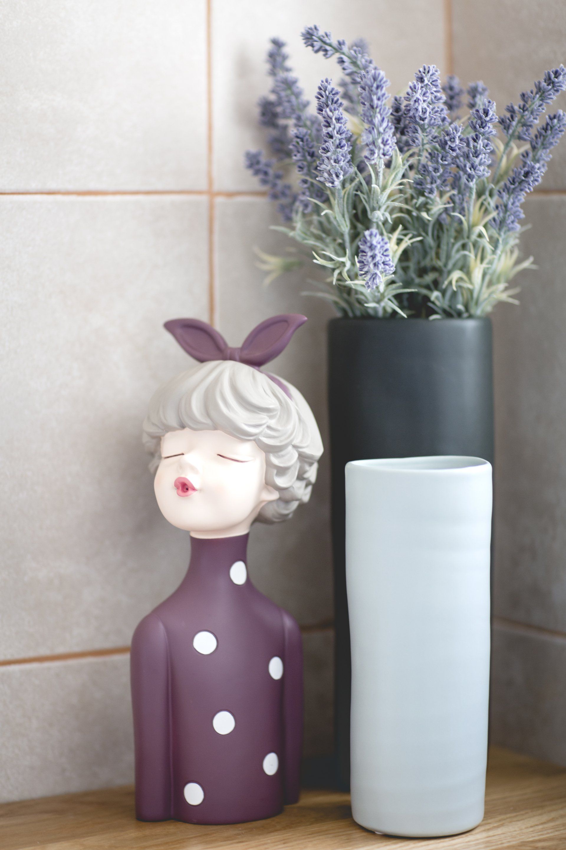 פסל דקורטיבי של אישה ועציץ לבנדר בחדר רחצה