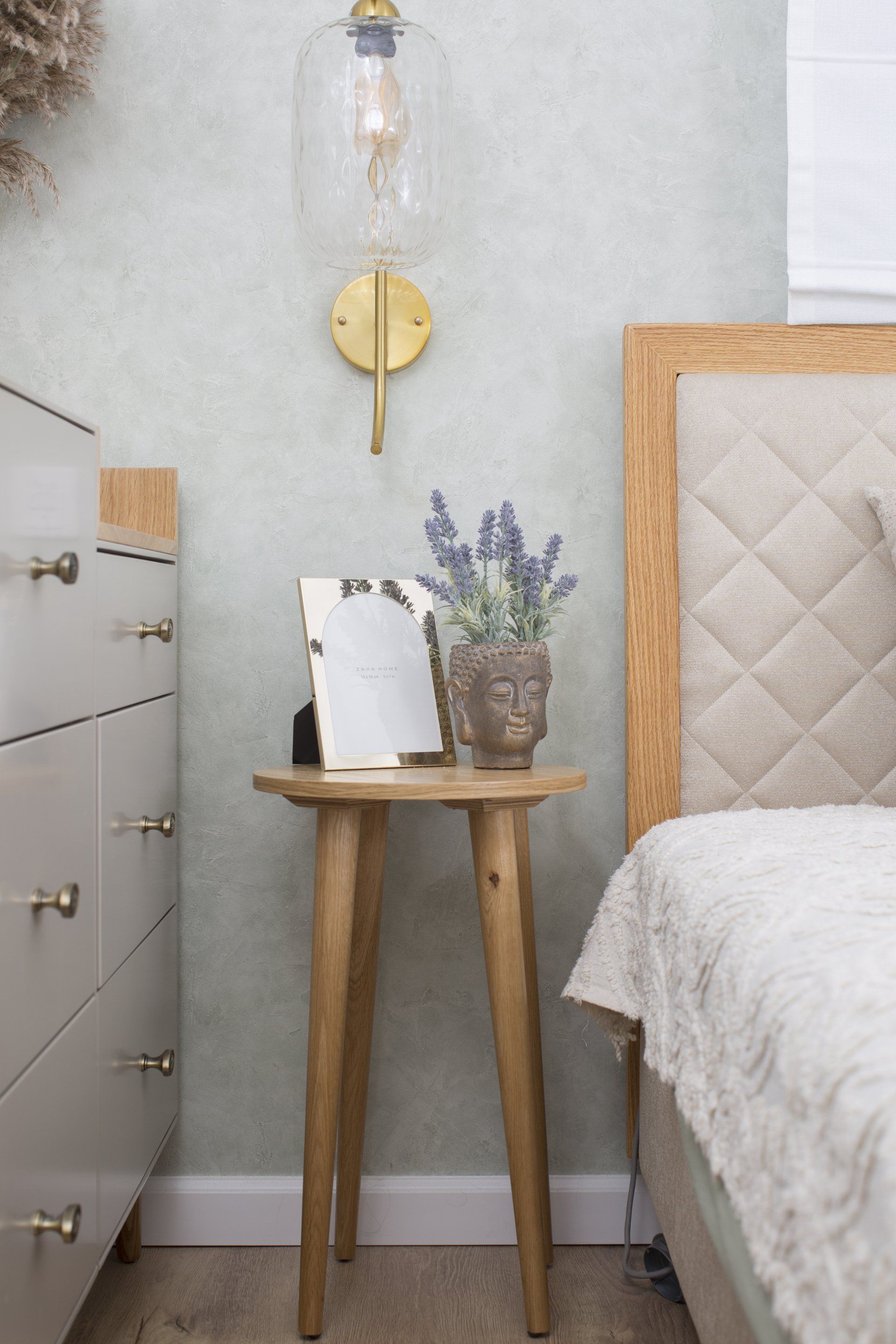 מיטת עם גב מיטה משולב בד ועץ , כסא ליד מיטה ושידה אפורה