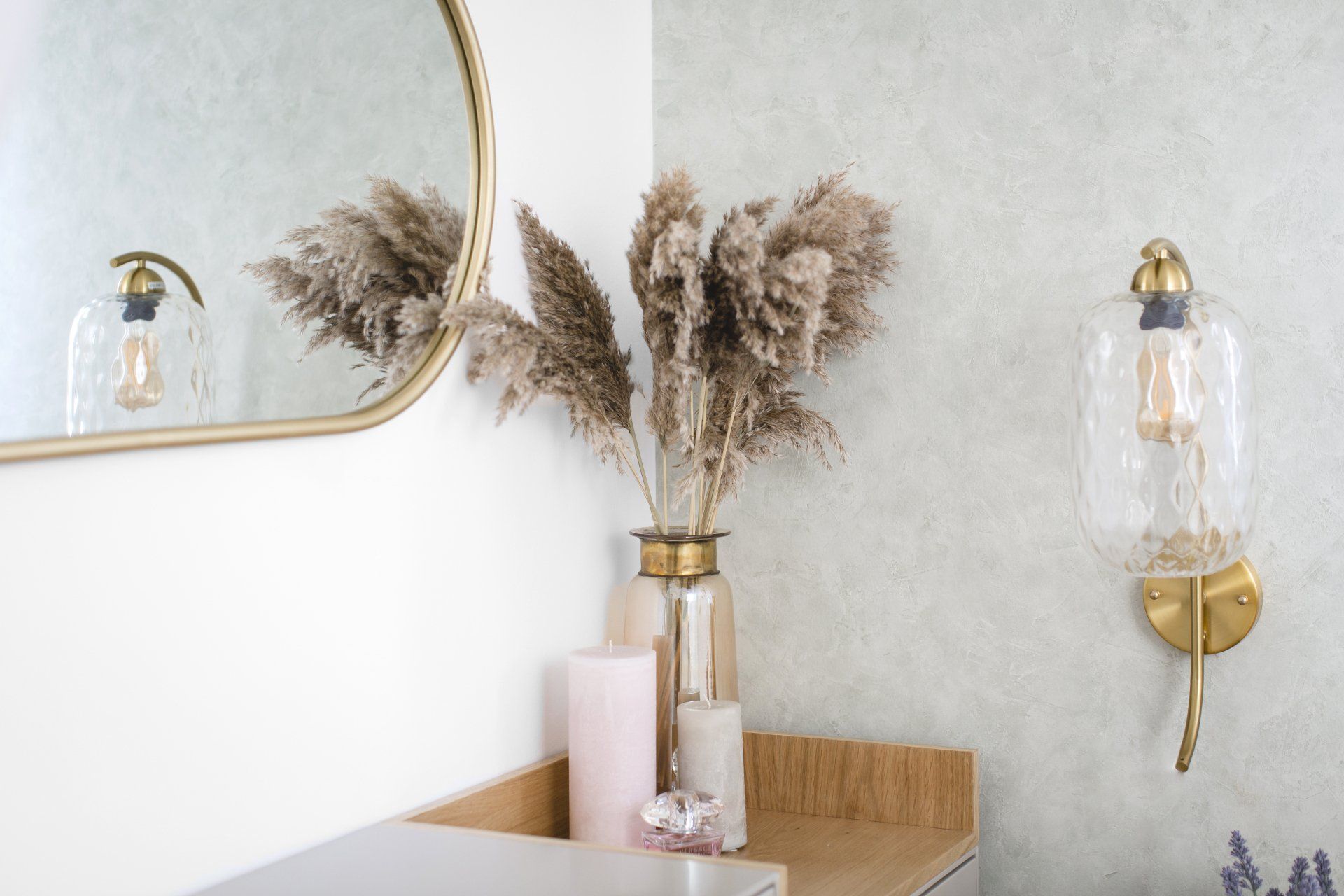 אגרטל עם ענפי פאמפאס באגרטל מוזהב ולצידו נר ורוד