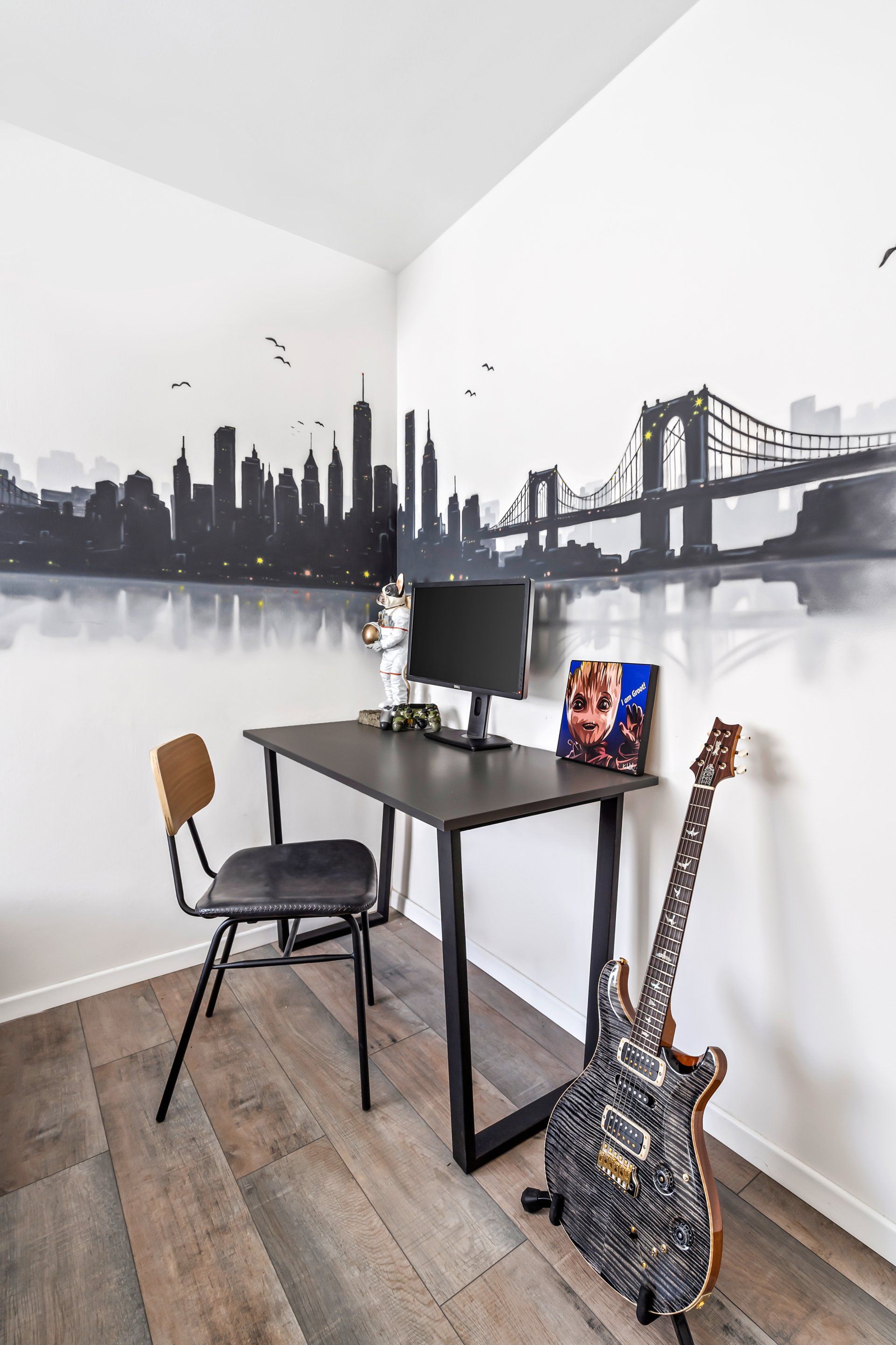 פינת עבודה בחדר מתבגר עם שולחן מחשב וגיטרה חשמלית